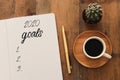 Business concept of top view 2020 goals list with notebook, cup of coffee over wooden desk Royalty Free Stock Photo