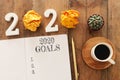 Business concept of top view 2020 goals list with notebook, cup of coffee over wooden desk Royalty Free Stock Photo