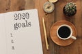 Business concept of top view 2020 goals list with notebook, cup of coffee over wooden desk Royalty Free Stock Photo