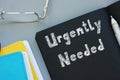 Business concept about Urgently Needed with sign on the page