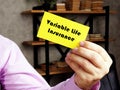 Business concept about Variable Life Insurance with phrase on the yelow business card