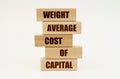 On a white surface are wooden blocks with the inscription - WEIGHT AVERAGE COST OF CAPITAL