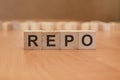 wooden cubes with the inscription - REPO, brown background