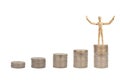 Wooden figure mannequin standing on the top of stacked silver coins isolated on white background. Royalty Free Stock Photo