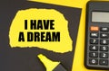 On a yellow background, a calculator, a black sheet, a marker and a yellow torn sheet with the inscription - I HAVE A DREAM