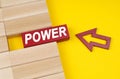 On a yellow surface are wooden blocks and an arrow pointing to a block with the inscription - POWER Royalty Free Stock Photo