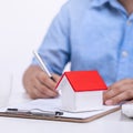 Business concept - Young Asian man in blue shirt calculates, signs agreement contract to buy a house loan payment, paying