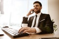 Business concept. Young businessman sitting at the office table happy talking on a cell phone getting good news about Royalty Free Stock Photo