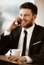 Business concept. Young businessman sitting at the office table happy talking on a cell phone getting good news about Royalty Free Stock Photo