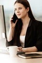 Business concept. Young businesswoman sitting at the office table happy talking on a cell phone getting good news about Royalty Free Stock Photo