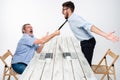 Business conflict. The two men expressing negativity while one man grabbing the necktie of her opponent