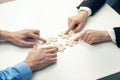 business cooperation concept - businessmen`s connecting puzzle