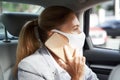 Business during coronavirus. Business woman wearing protective face mask talking by mobile phone while sitting on back
