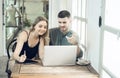 business couple Cheerful woman using laptop in coffee shop Young businessman and happy girlfriend smiling while working together Royalty Free Stock Photo