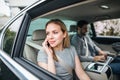 Business couple with laptop sitting on back seats in car, working. Royalty Free Stock Photo