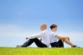 Business couple sitting back to back on grass Royalty Free Stock Photo