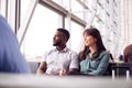 Business Couple Sitting By Window Waiting In Airport Departure Lounge Royalty Free Stock Photo