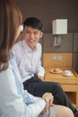 Business couple smiling and sitting on bed in hotel room