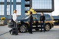 Business couple walk with a suitcase to a car during a trip