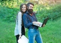 Business couple of woman and man with devices of laptop glasses mobile phone paper folder and standing outdoor on green Royalty Free Stock Photo