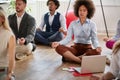 Business coworkers meditating at work, sitting on the floor with legs crossed and eyes closed. modern, casual, business, meditatio