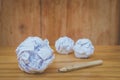 Used pencil with many white crumpled paper ball put on wooden floor. Royalty Free Stock Photo