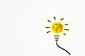 Yellow crumpled paper ball light bulb bright growing on white background. Royalty Free Stock Photo