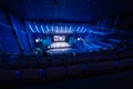 Business crowd attending international seminar in large blue illuminated auditorium