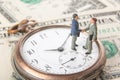 Business deal or agreement and success concept. Two miniature businessmen shaking hands while standing on vintage old clock and am Royalty Free Stock Photo