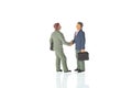 Business deal or agreement and success concept. Two miniature businessmen shaking hands. on white background. Royalty Free Stock Photo