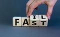 Business and design concept. Man hand flips wooden cubes with words `fail fast` concept on beautiful grey background, copy space