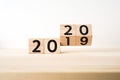 Business and design concept - surreal abstract geometric floating wooden cube with word 2020 and 2019 concept on wood floor and wh Royalty Free Stock Photo