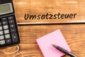 Business desk with paper, pen and calculator and german text Umsatzsteuer, in english value added tax Royalty Free Stock Photo