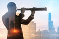 Business development and personal growth concept with businessman silhouette looking through a spyglass at city skyline background