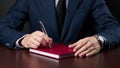 business disappointment concept. businessman in formal wear sitting at the desk and holds silver pen at his arm