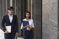 Business discussions between Caucasian people. Business people are talking and smiling while standing on stair of the office