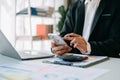 business documents on office table with smart phone and digital tablet and graph financial and woman working at office Royalty Free Stock Photo