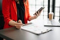 business documents on office table with smart phone and digital tablet and graph financial and woman working at office Royalty Free Stock Photo