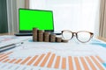 Business documents on table with laptop computer and coin stacks and graph financial diagram. laptop green screen Royalty Free Stock Photo