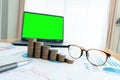 Business documents on table with laptop computer and coin stacks and graph financial diagram. laptop green screen Royalty Free Stock Photo