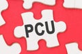 On a red background, among white puzzles lies a puzzle with the inscription - PCU Royalty Free Stock Photo