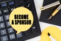 There is a calculator, a pen, a marker and a sticker with the inscription - BECOME A SPONSOR