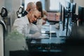 Business employee concentrates on work at a desk with notebooks and multiple monitors in a modern office Royalty Free Stock Photo