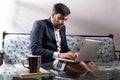 business employee using computer sitting on sofa