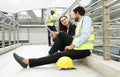 business engineer colleague chatting work by tablet online while sitting on walkway of building