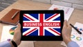 Business English app against Britain flag on tablet in female hands, tutorial