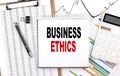 BUSINESS ETHICS text on notebook with chart, calculator and pen Royalty Free Stock Photo