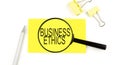 BUSINESS ETHICS text on the sticker through magnifier. View from above. Business concept Royalty Free Stock Photo