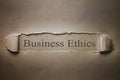 Business Ethics words on torn paper.