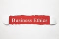 Business Ethics words on torn paper.